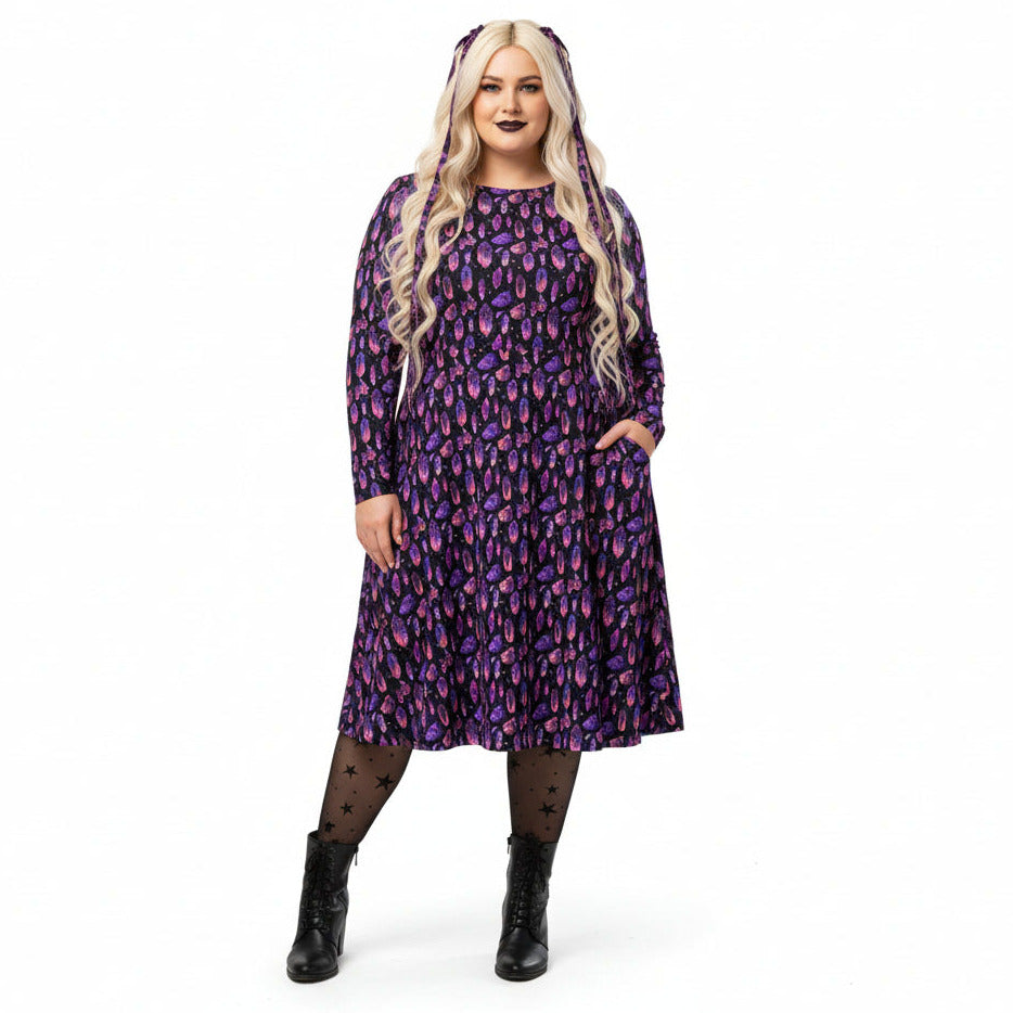 Woman wearing a purple mystical crystal print dress on a white background