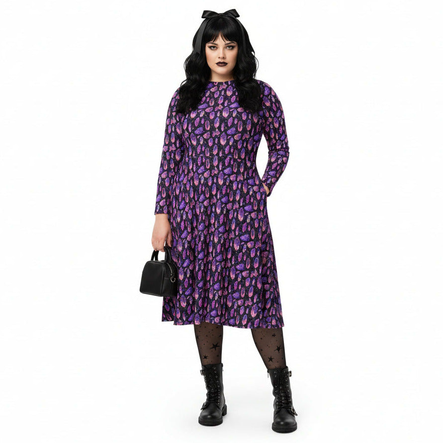 Woman wearing a purple crystal print  dress on a white background