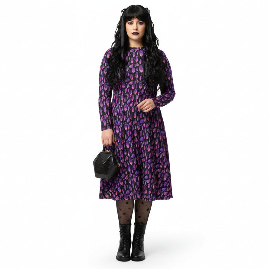 Woman wearing a purple crystal print  dress on a white background