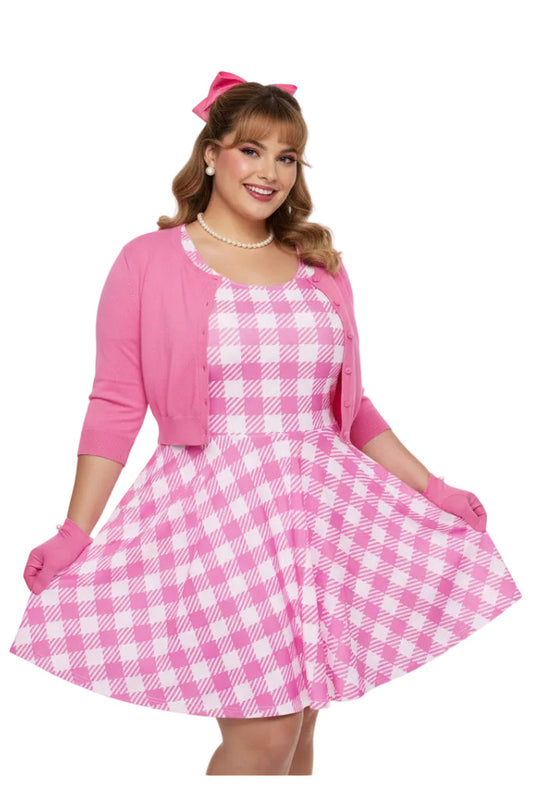 Plus size woman wearing a pink and white gingham 1950s vintage style fit and flare swing dress with pink gloves and a hair bow.