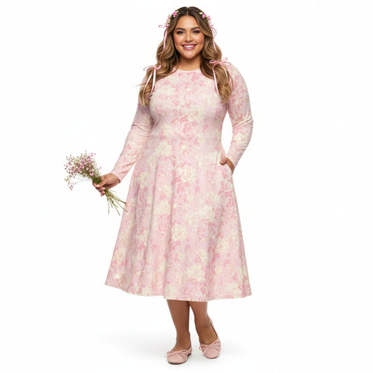 Woman wearing a pink floral dress holding flowers on a white background