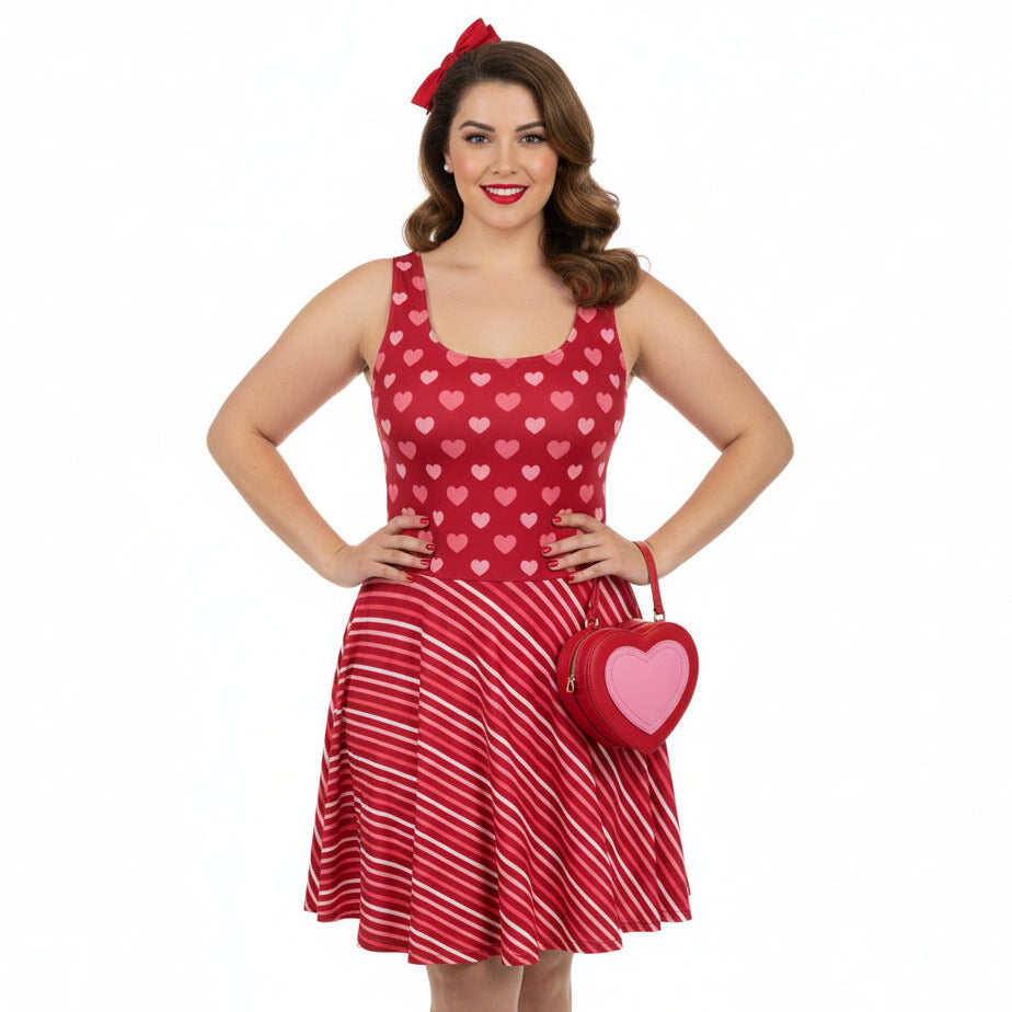 Woman wearing a red dress with heart patterns and holding a matching heart-shaped bag on a white background