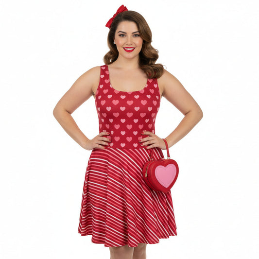 Woman wearing a red dress with heart patterns and holding a matching heart-shaped bag on a white background
