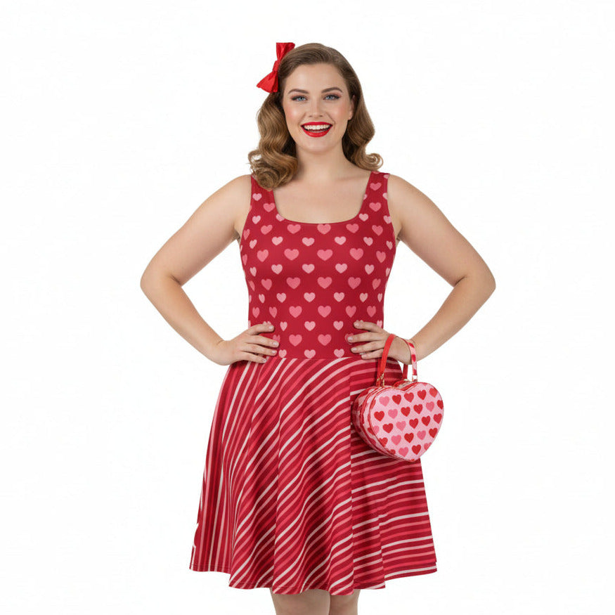 Woman wearing a red dress with heart patterns and holding a matching heart-shaped handbag on a white background