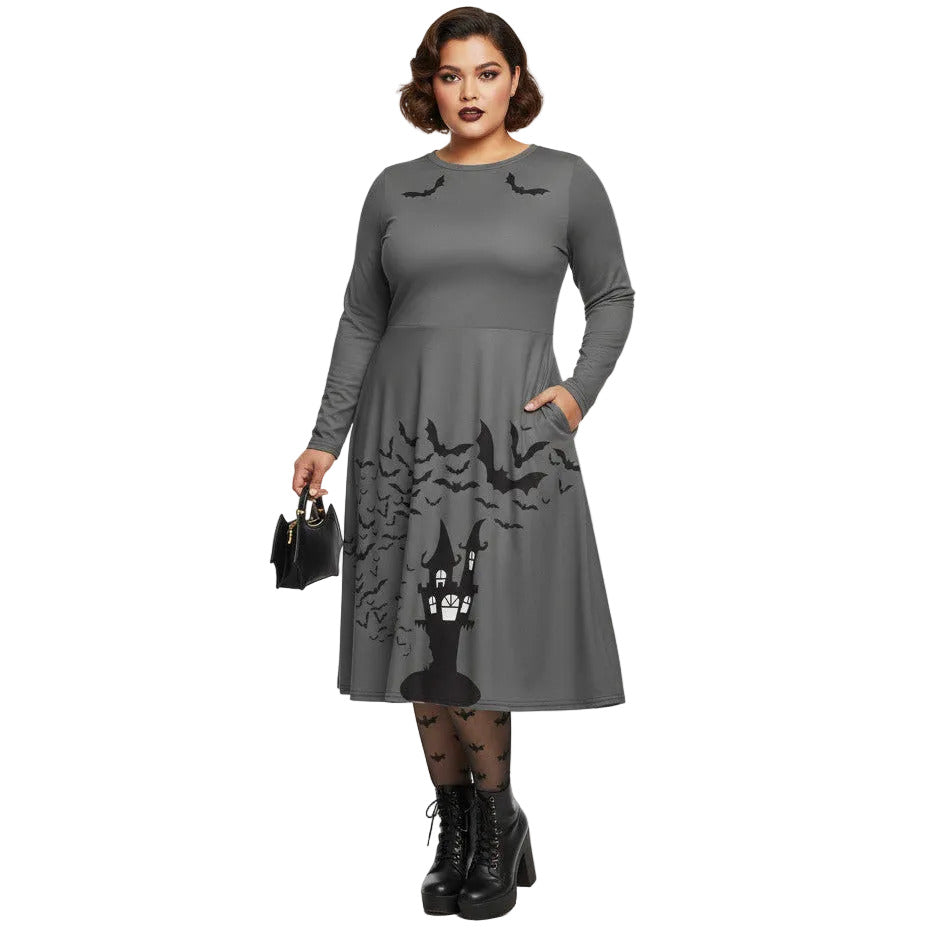 Plus size woman wearing a grey long sleeve goth pinup dress with black bat and haunted house print featuring functional side pockets.