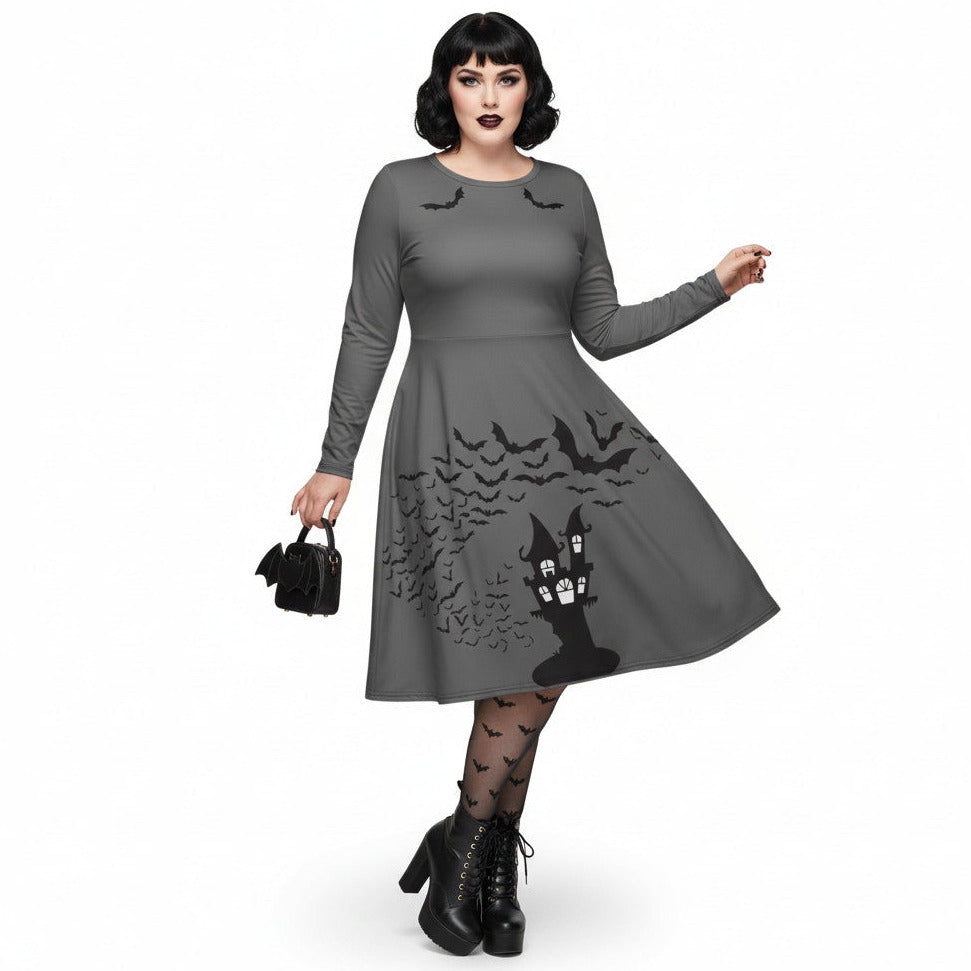 Plus size woman wearing a grey long sleeve goth pinup dress with black bat and haunted house print featuring functional side pockets.