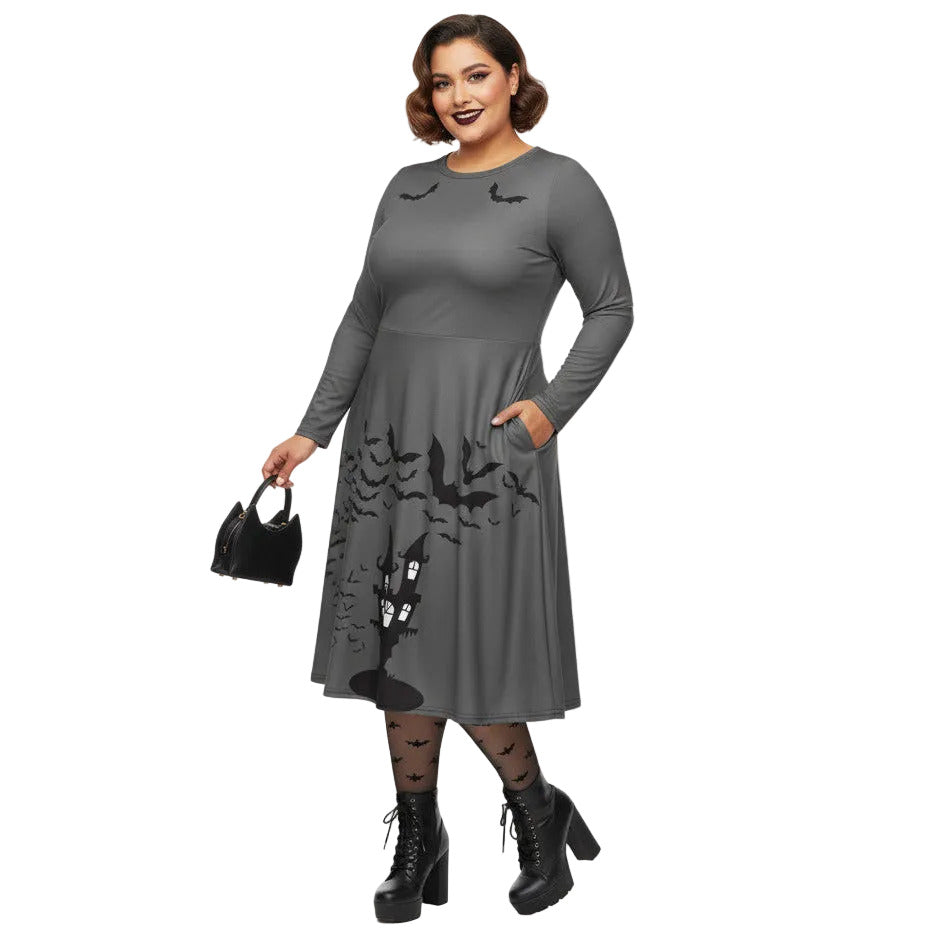 Plus size woman wearing a grey long sleeve goth pinup dress with black bat and haunted house print featuring functional side pockets.