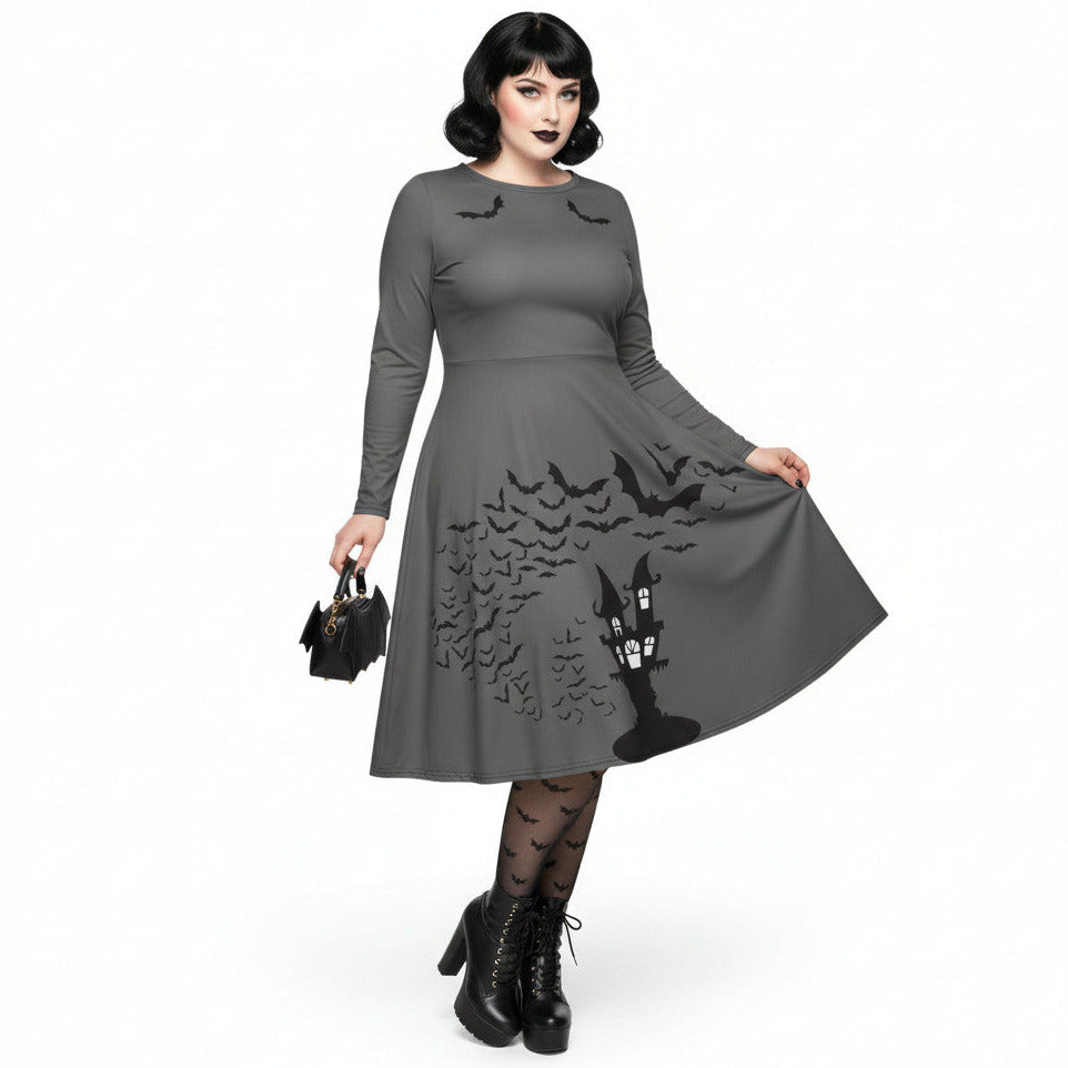 Plus size woman wearing a grey long sleeve goth pinup dress with black bat and haunted house print featuring functional side pockets.