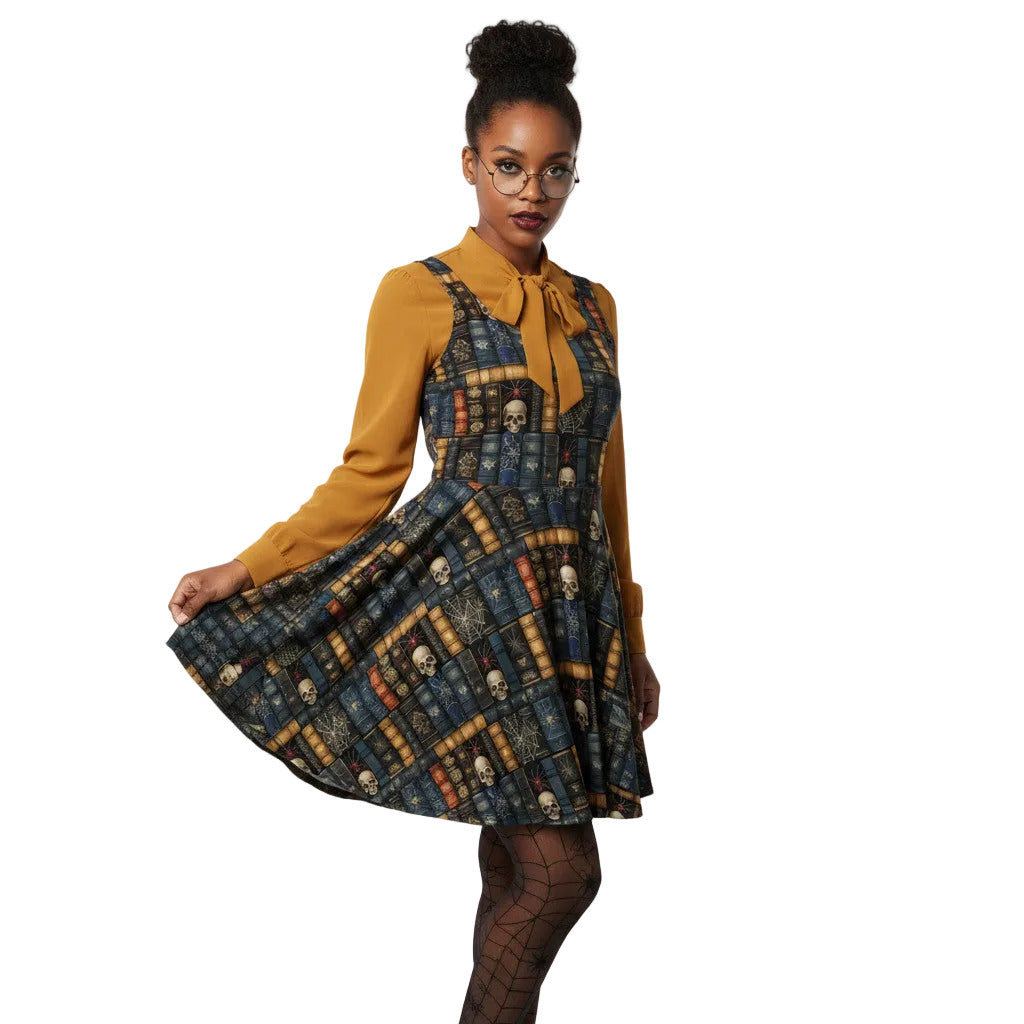 Woman wearing a dark academia skater dress with a vintage bookshelf and skull print, styled with a golden bronze pussybow blouse and glasses.