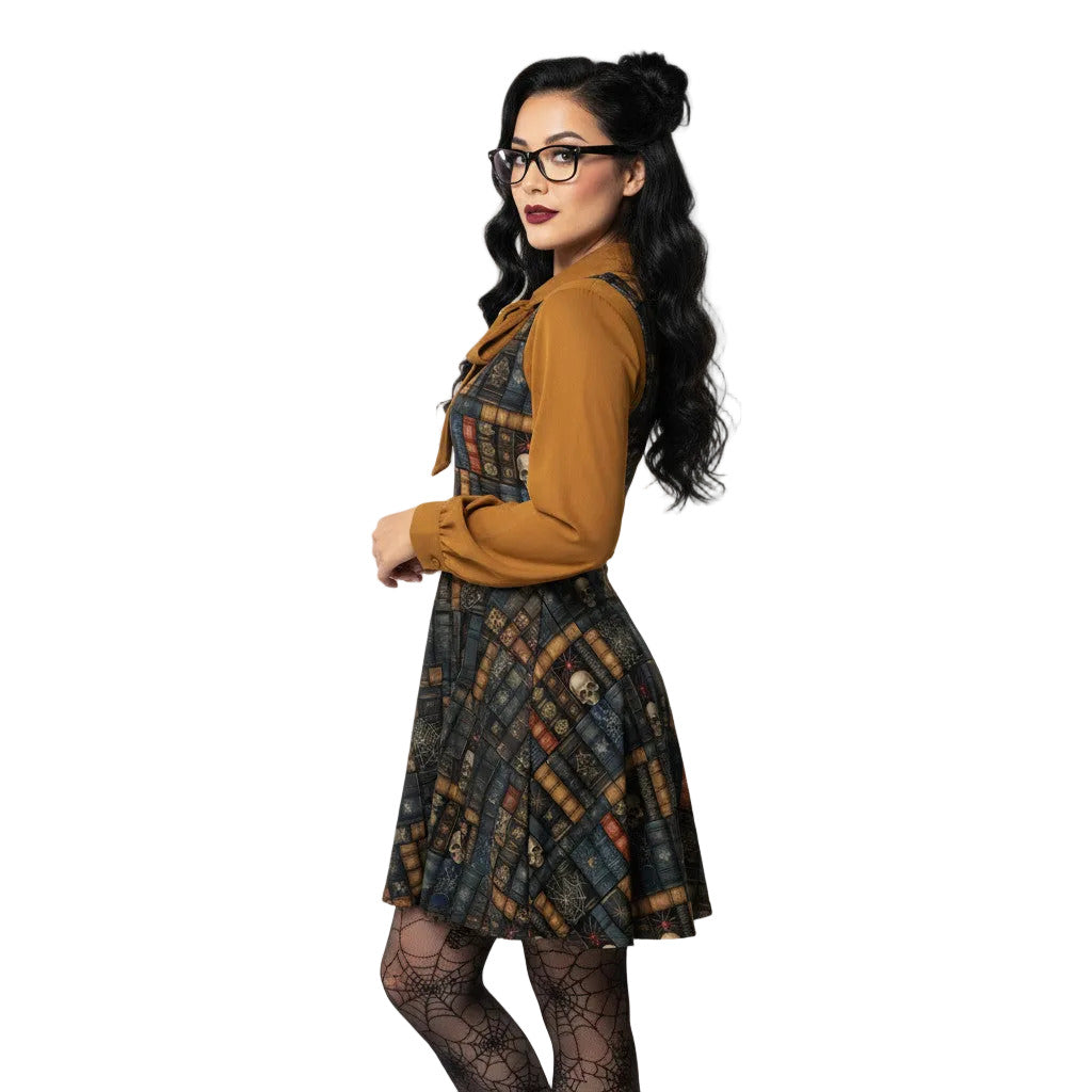 Woman wearing a dark academia skater dress with a vintage bookshelf and skull print, styled with a mustard yellow pussybow blouse and glasses.