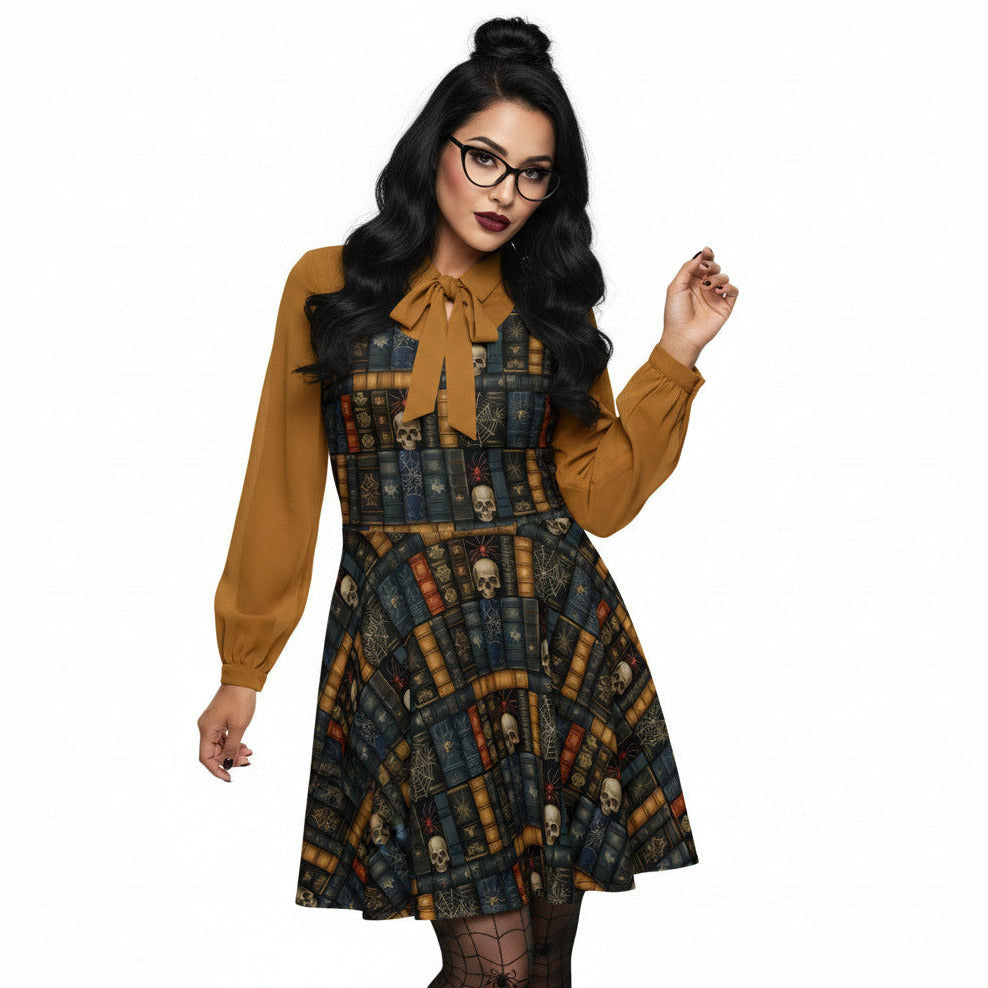 Woman wearing a dark academia skater dress with a vintage bookshelf and skull print, styled with a mustard yellow pussybow blouse and round glasses.