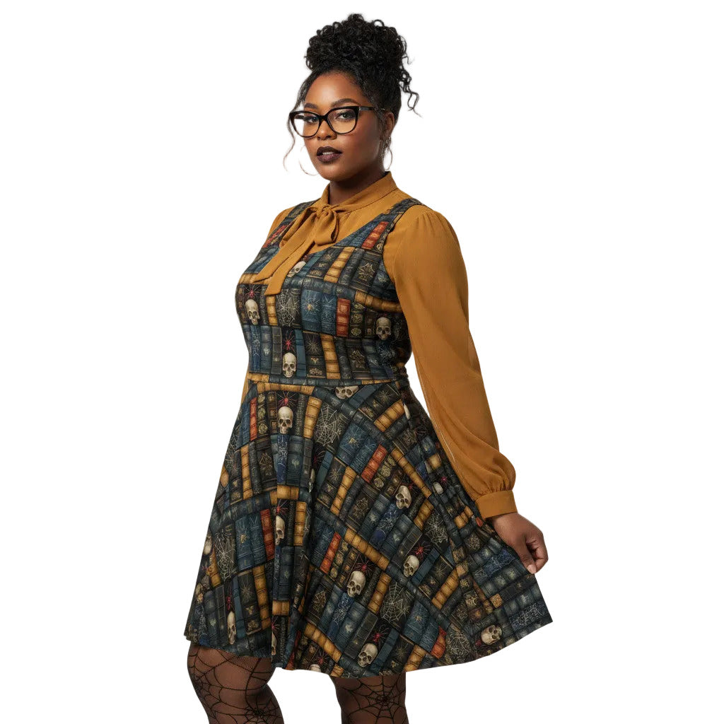 Woman wearing a dark academia skater dress with a vintage bookshelf and skull print, styled with a mustard yellow pussybow blouse and glasses.