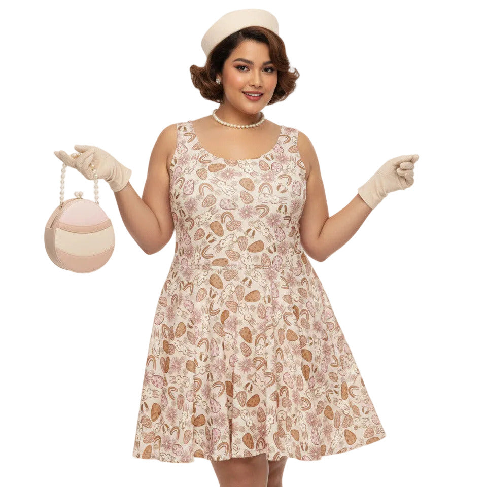 Plus size woman wearing a 1950s vintage style swing dress with pink and tan Easter egg and bunny print, featuring a sleeveless scoop neck and flared skirt.