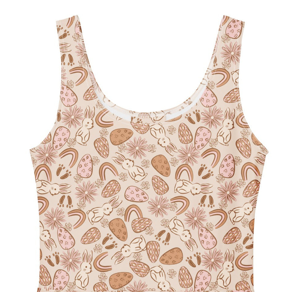 1950s vintage style swing dress with pink and tan Easter egg and bunny print, featuring a sleeveless scoop neck and flared skirt.