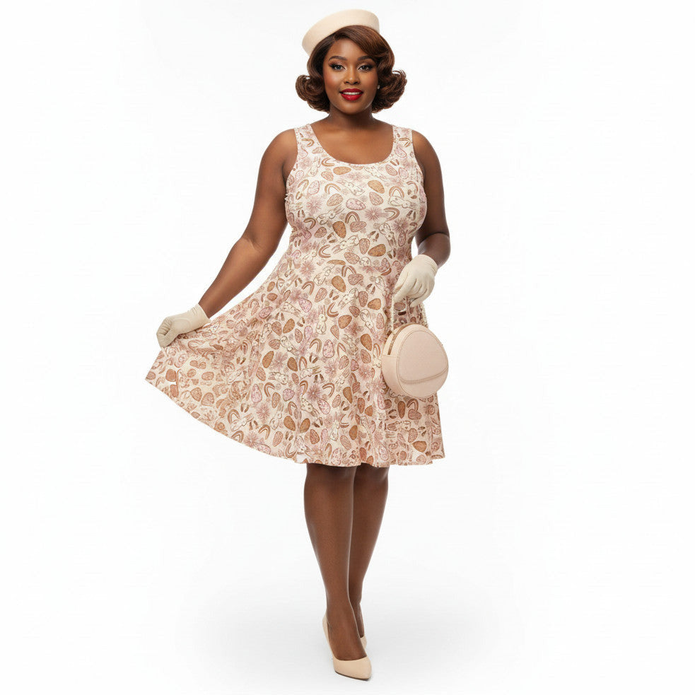 Plus size woman wearing a 1950s vintage style swing dress with pink and tan Easter egg and bunny print, featuring a sleeveless scoop neck and flared skirt.