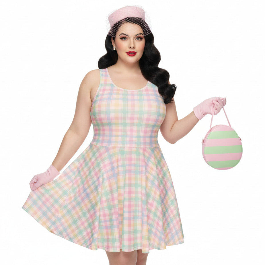 Plus size woman wearing a pastel pink and green gingham 1950s vintage style swing dress with matching pillbox hat and gloves.