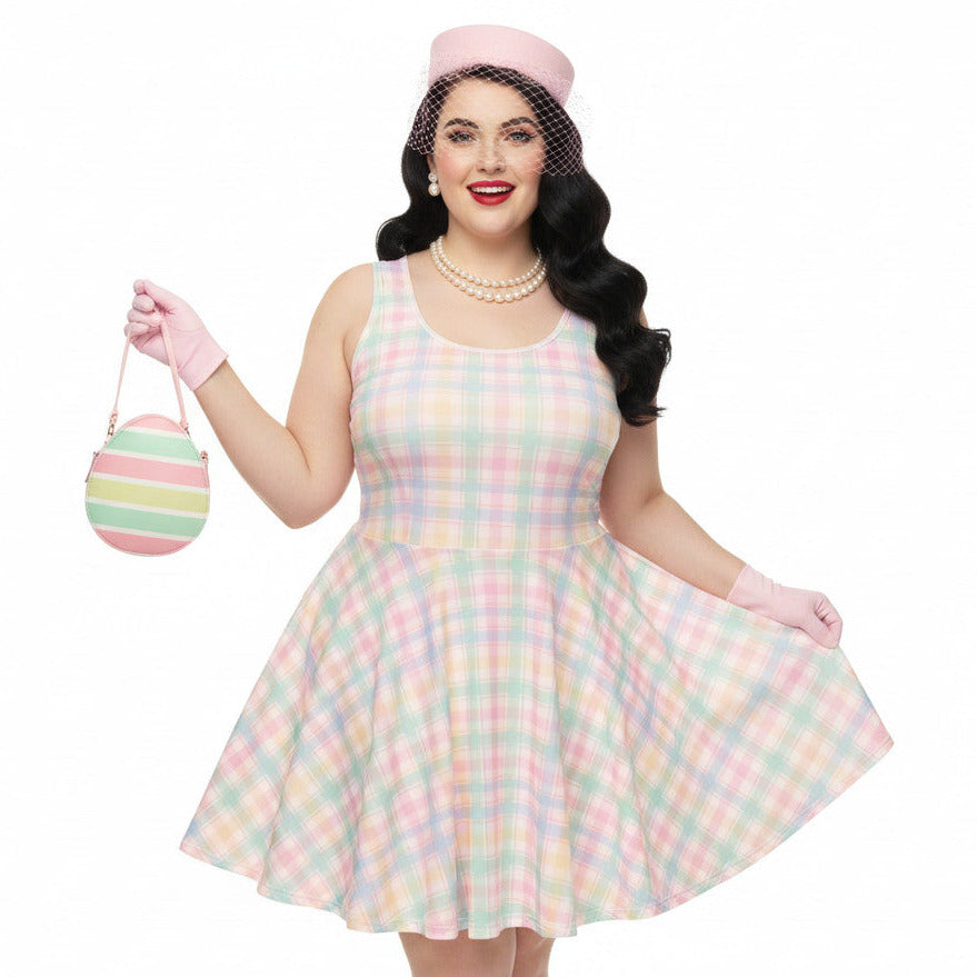Plus size woman wearing a pastel pink and green gingham 1950s vintage style swing dress with matching pillbox hat and gloves.