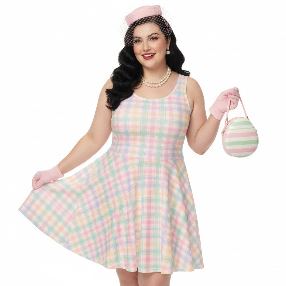 Plus size woman wearing a pastel pink and green gingham 1950s vintage style swing dress with matching pillbox hat and gloves.