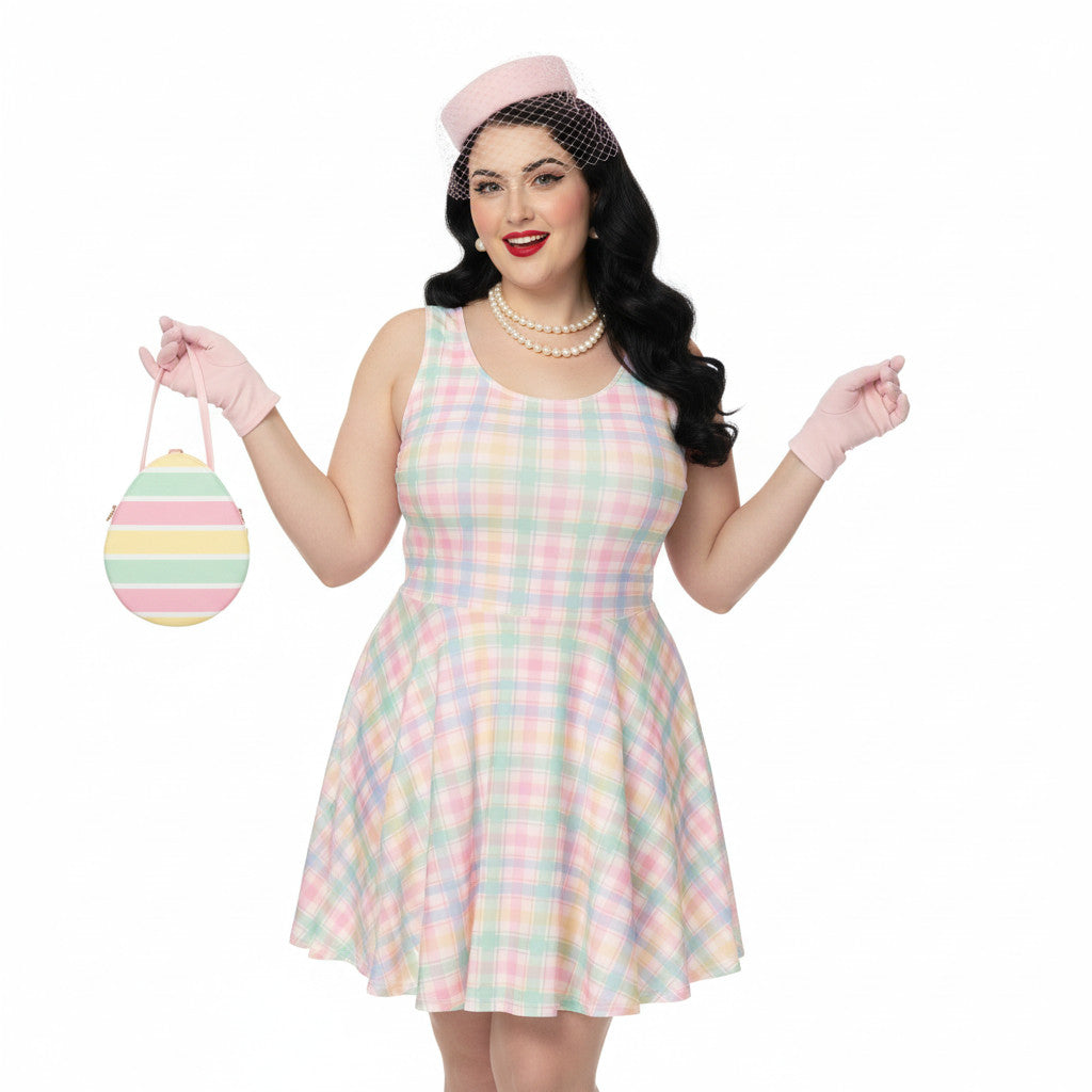 Plus size woman wearing a pastel pink and green gingham 1950s vintage style swing dress with matching pillbox hat and gloves.