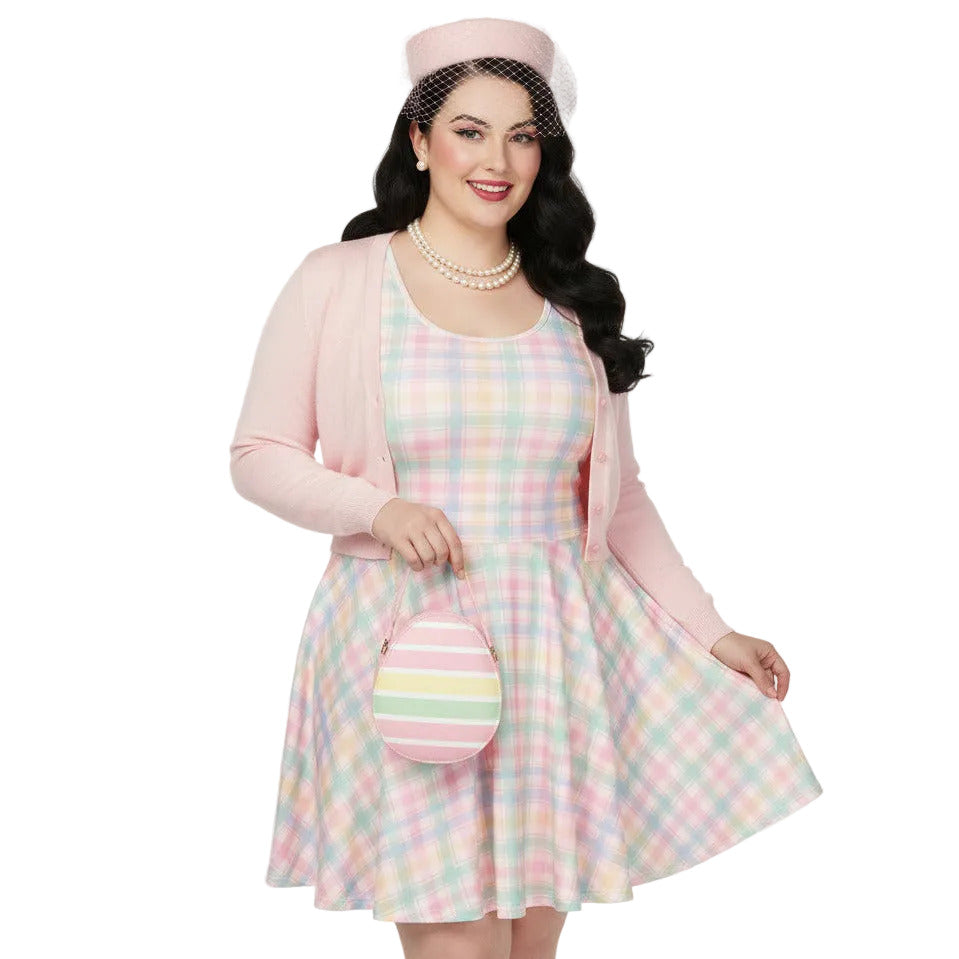 Plus size woman wearing a pastel pink and green gingham 1950s vintage style swing dress with matching pillbox hat.