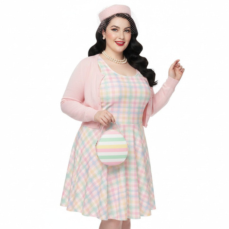 Plus size woman wearing a pastel pink and green gingham 1950s vintage style swing dress with matching pillbox hat.