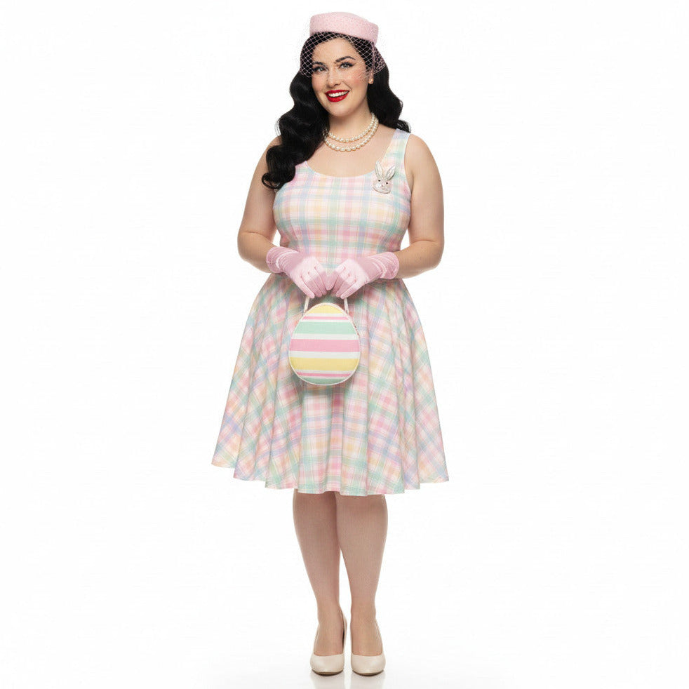 Plus size woman wearing a pastel pink and green gingham 1950s vintage style swing dress with matching pillbox hat and gloves.