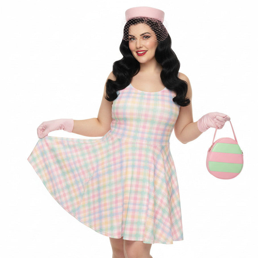 Plus size woman wearing a pastel pink and green gingham 1950s vintage style swing dress with matching pillbox hat and gloves.