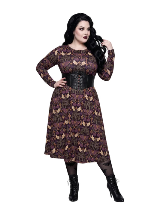 Plus size woman wearing a purple Whimsigoth gothic moth pattern long sleeve dress with pockets.