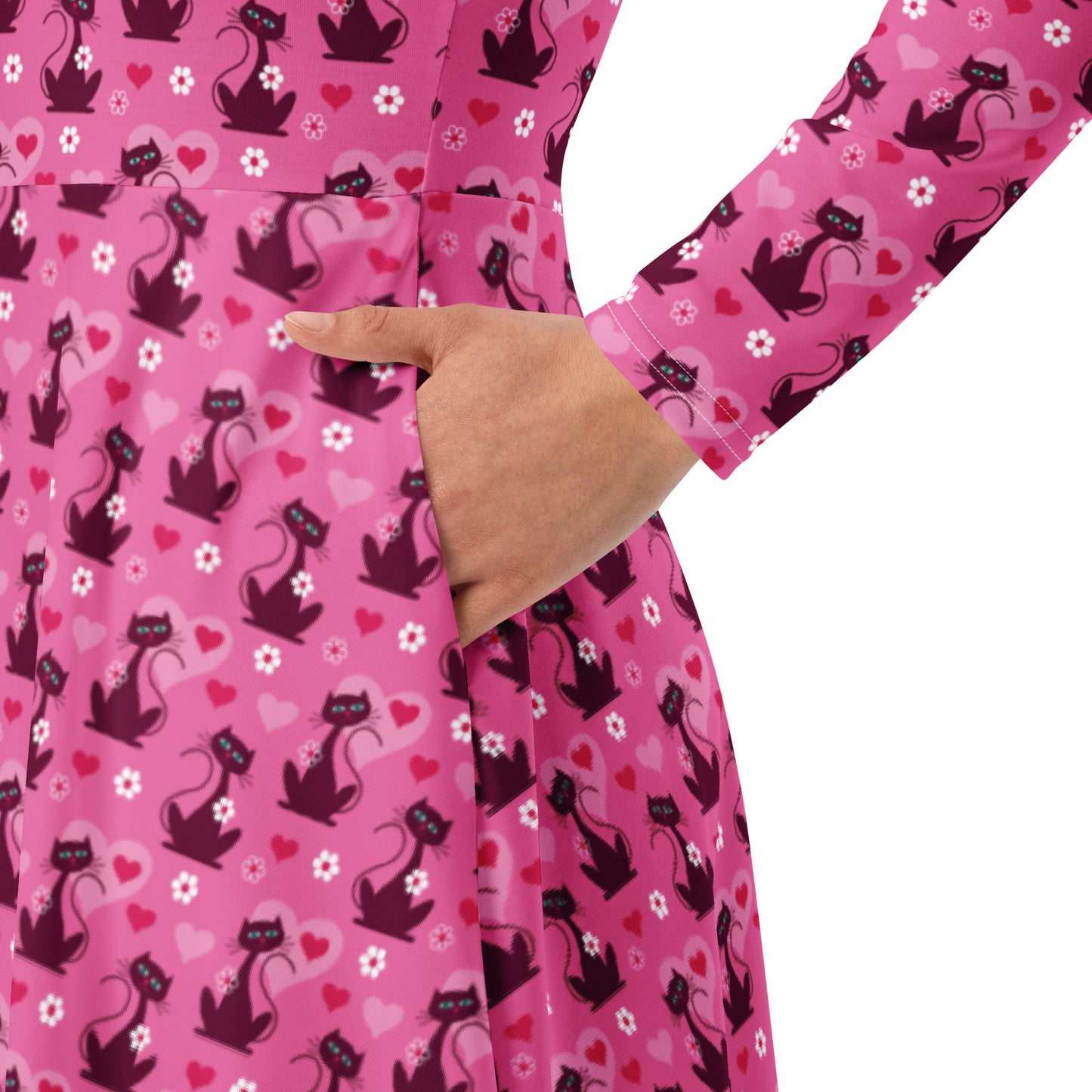 woman wearing a pink retro-style long sleeve vintage 1950s dress with cat print and functional side pockets.