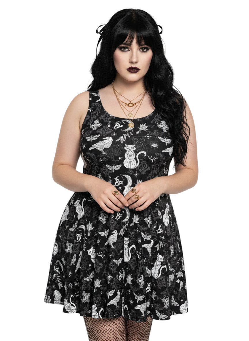 Plus size woman wearing a Whimsigoth fit and flare dress with witchy cat and celestial moon prints.