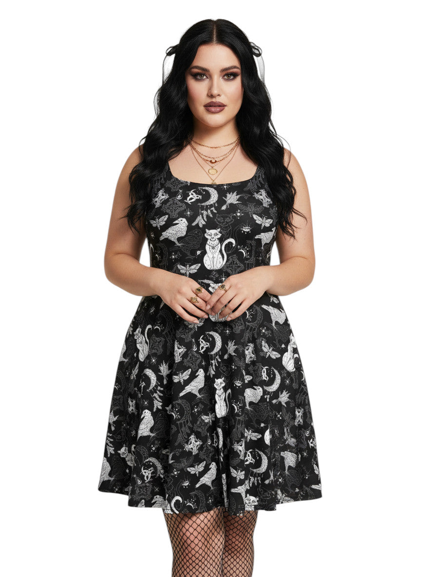 Plus size woman wearing a Whimsigoth fit and flare dress with witchy cat and celestial moon prints.