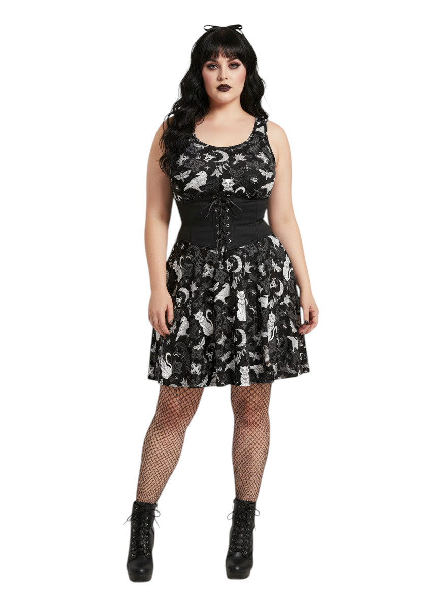 Woman wearing a Whimsigoth fit and flare dress with witchy cat and celestial moon prints.