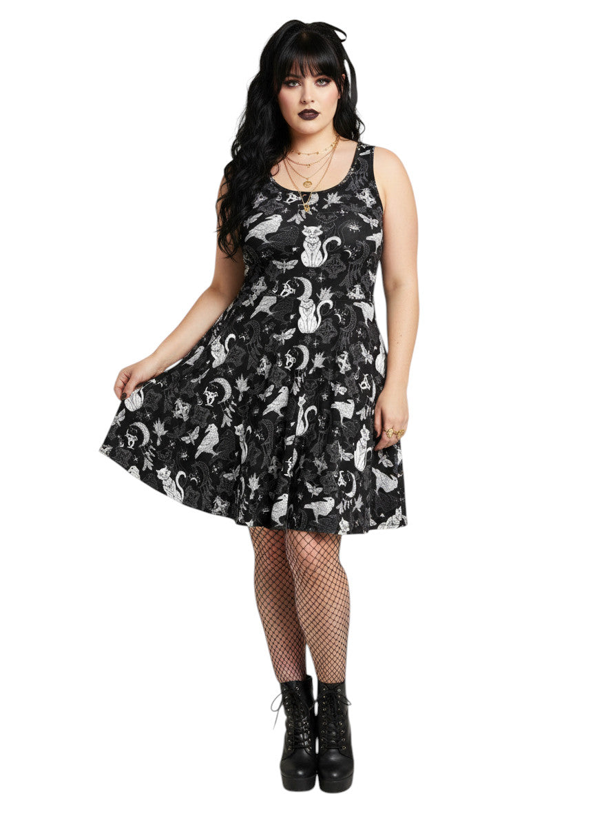 Woman wearing a Whimsigoth fit and flare dress with witchy cat and celestial moon prints.