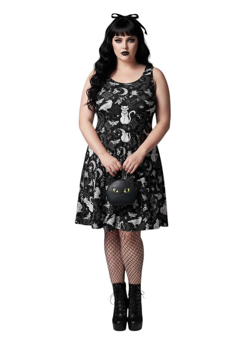 Woman wearing a Whimsigoth fit and flare dress with witchy cat and celestial moon prints.