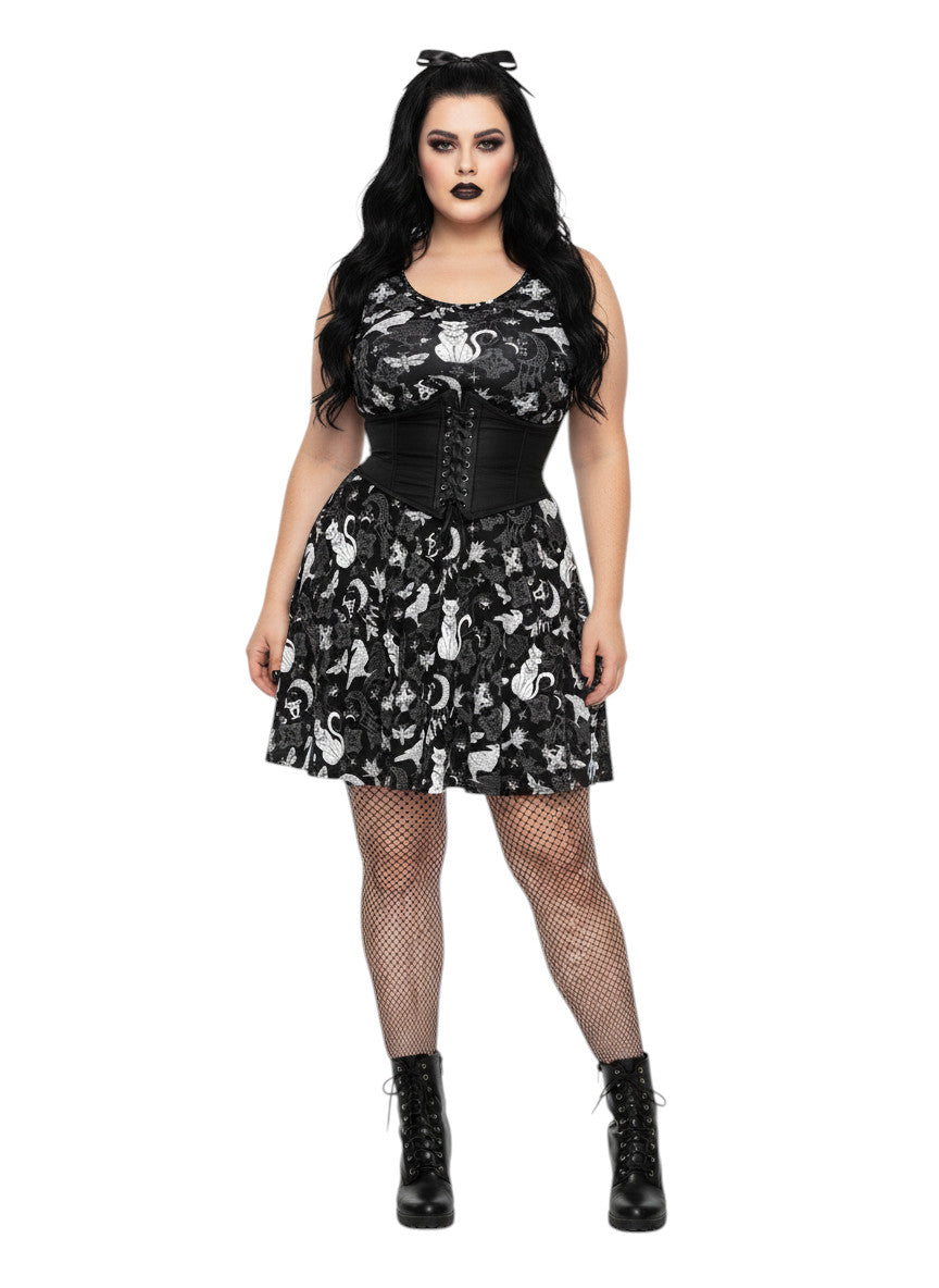 Woman wearing a Whimsigoth fit and flare dress with witchy cat and celestial moon prints.