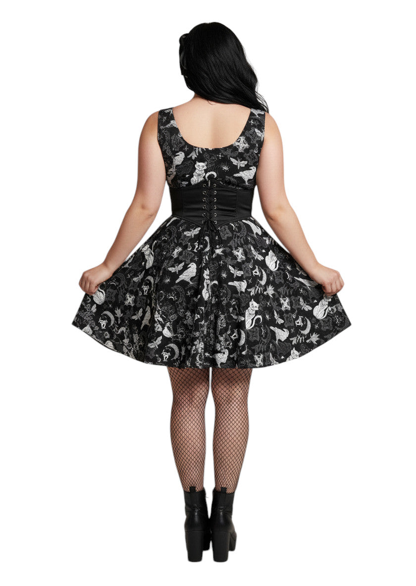 Plus size woman wearing a Whimsigoth fit and flare dress with witchy cat and celestial moon prints.