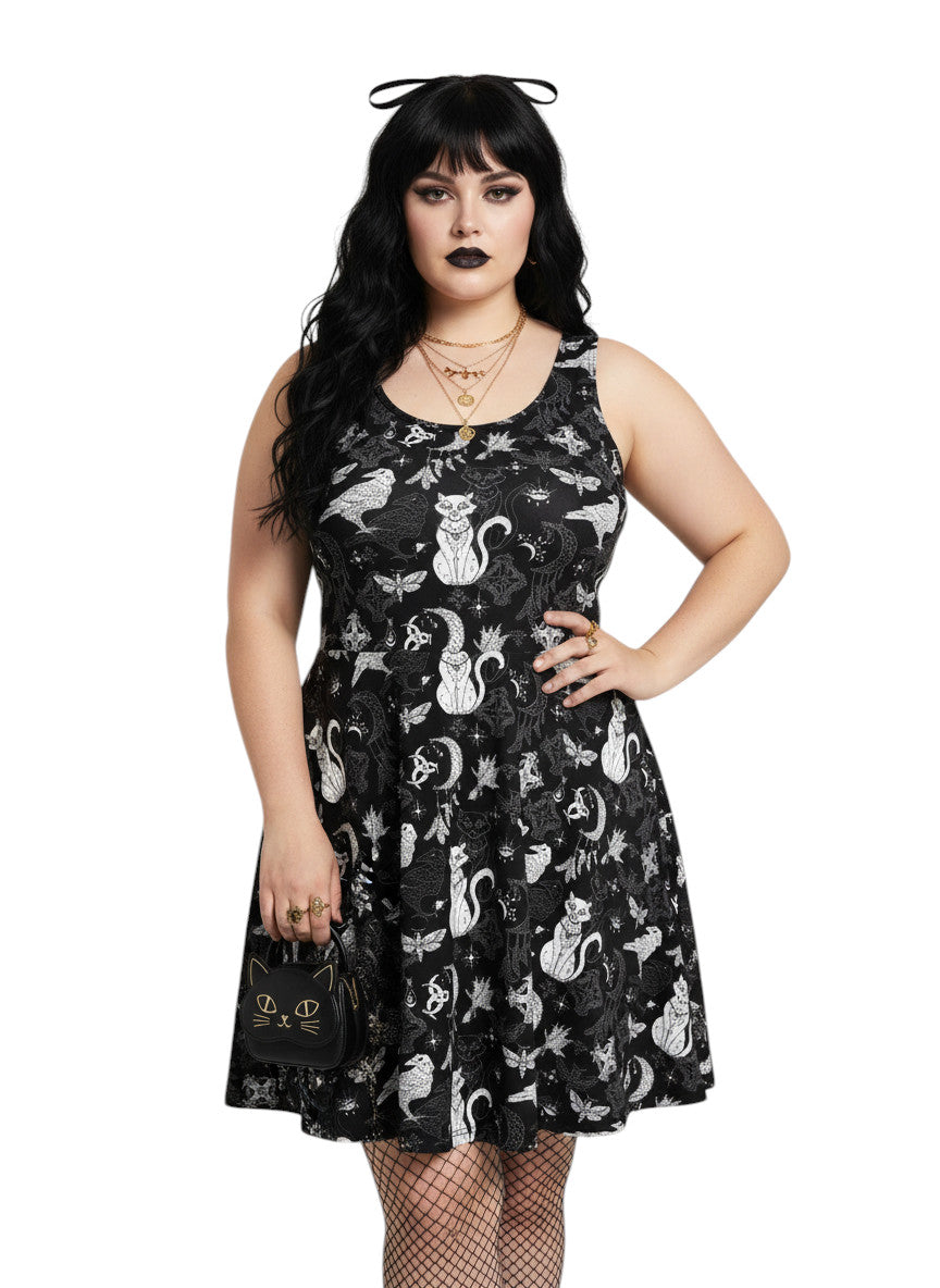 Plus size woman wearing a Whimsigoth fit and flare dress with witchy cat and celestial moon prints.