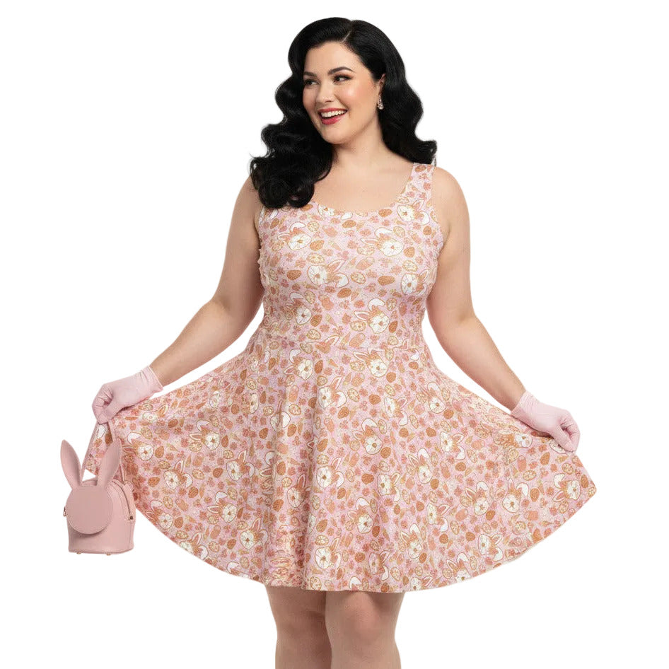 Plus size woman wearing a 1950s style pink Easter bunny print swing dress with a fit and flare silhouette.