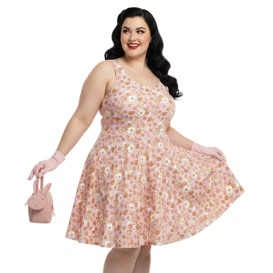 Plus size woman wearing a 1950s style pink Easter bunny print swing dress with a fit and flare silhouette.