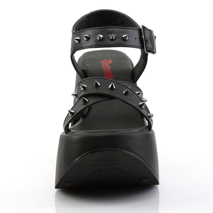 Black vegan leather platform wedge sandals with star cutout heel, silver cone spikes, and criss-cross ankle straps