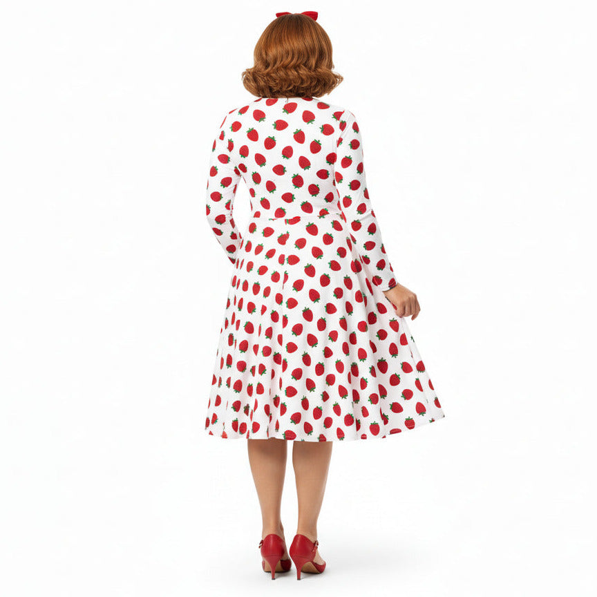 Woman wearing white and red strawberry print long sleeve dress on white background