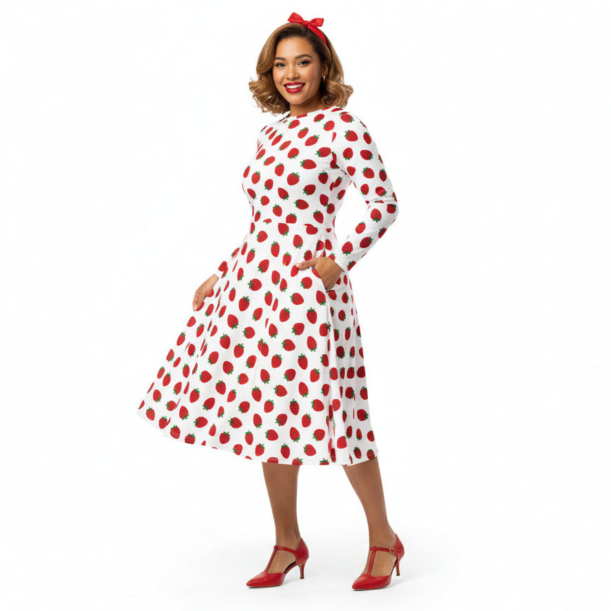 Woman wearing white and red strawberry print long sleeve dress on white background