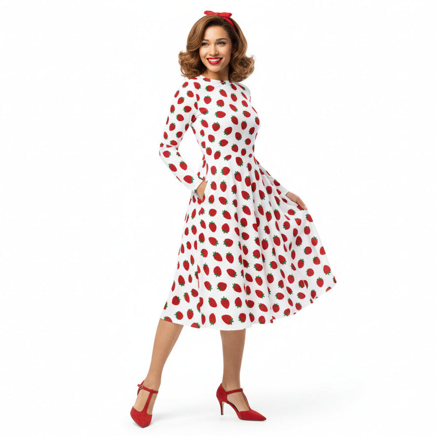 Woman wearing white and red strawberry print long sleeve dress on white background