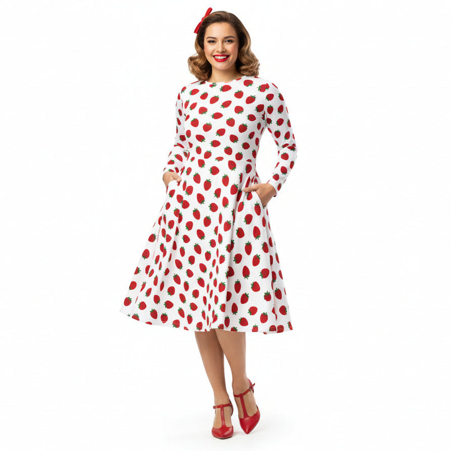 Woman wearing white and red strawberry print long sleeve dress on white background