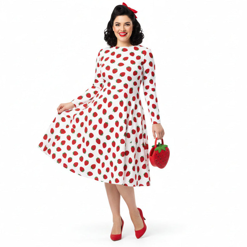 Woman wearing white and red strawberry print long sleeve dress on white background