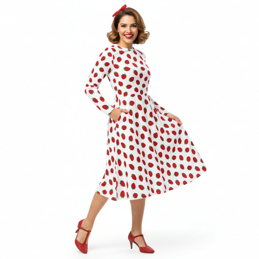 Woman wearing white and red strawberry print long sleeve dress on white background