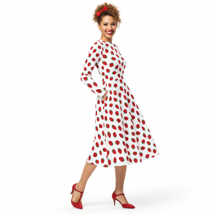 Woman wearing white and red strawberry print long sleeve dress on white background