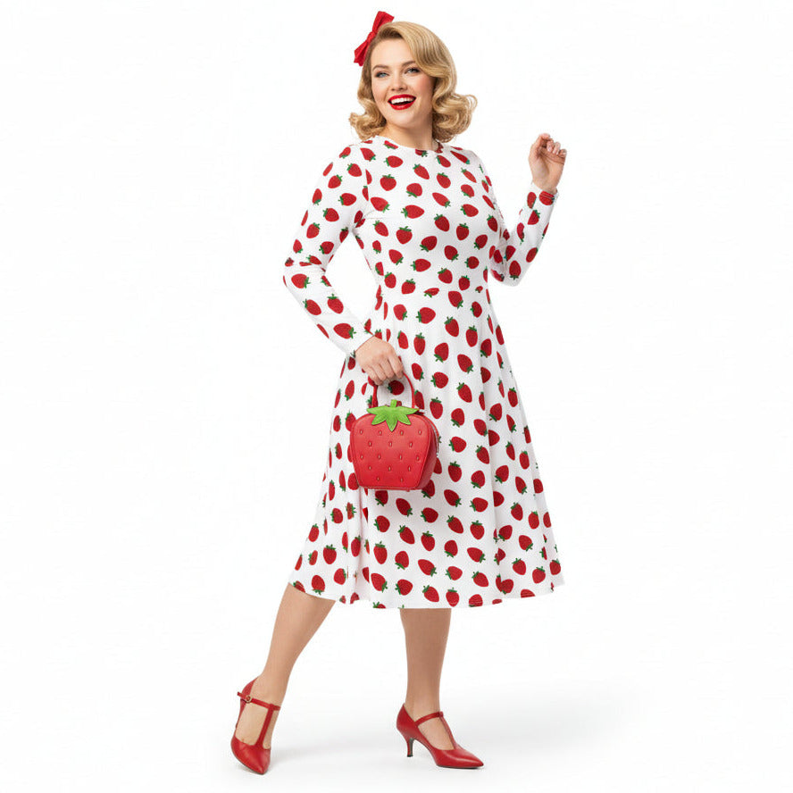 Woman wearing white and red strawberry print long sleeve dress on white background