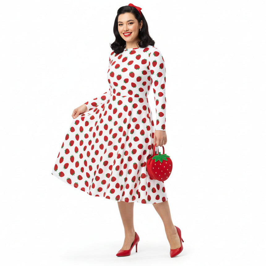 Woman wearing white and red strawberry print long sleeve dress on white background