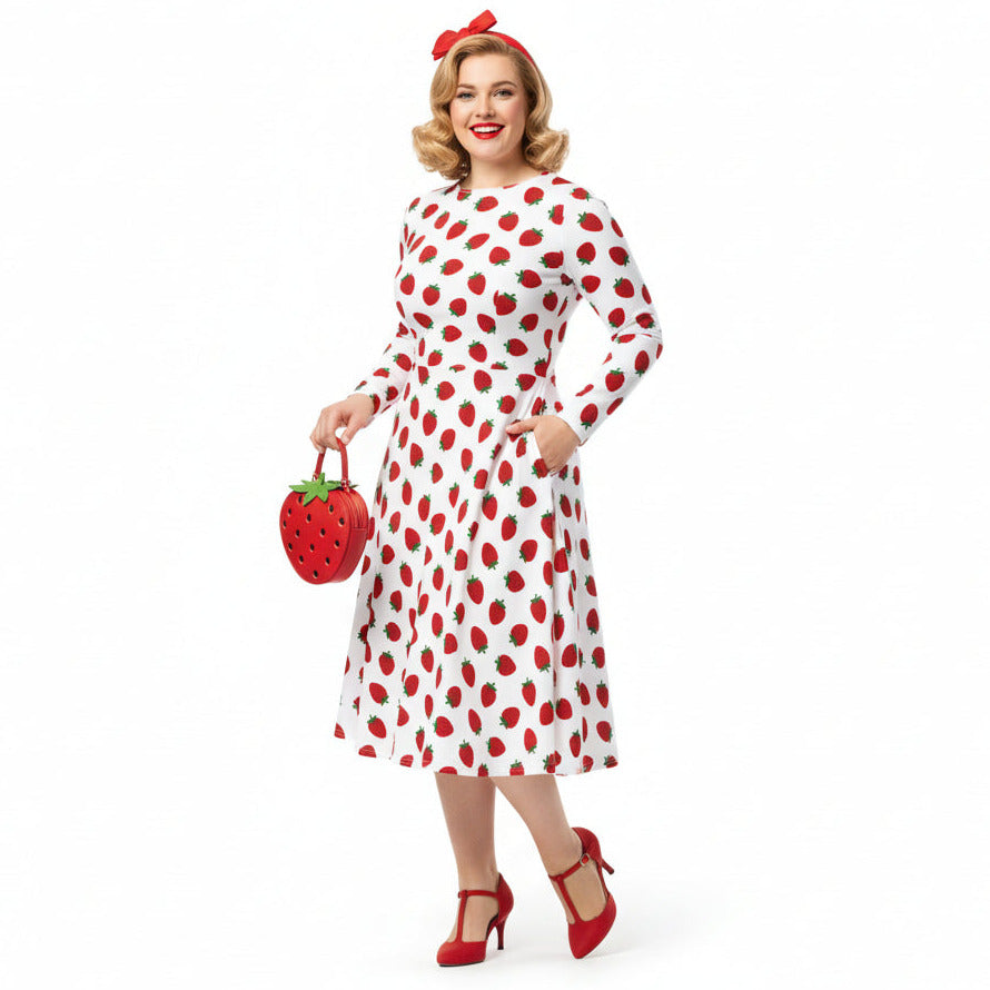 Woman wearing white and red strawberry print long sleeve dress on white background